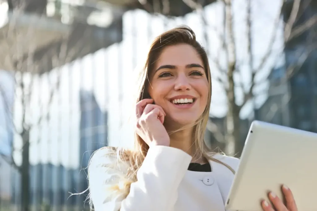 Woman in white blazer holding a tablet