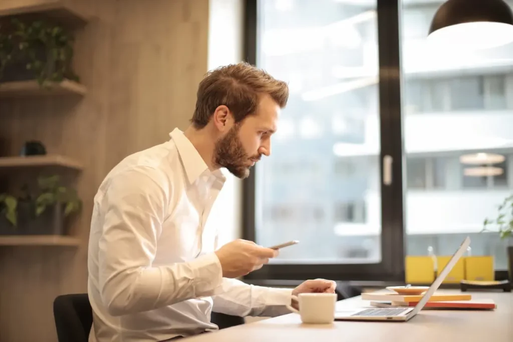 Man in white dress shirt working on laptop